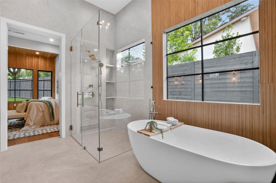 Luxurious spa bath features a freestanding tub and a glass-enclosed shower with contemporary fixtures.