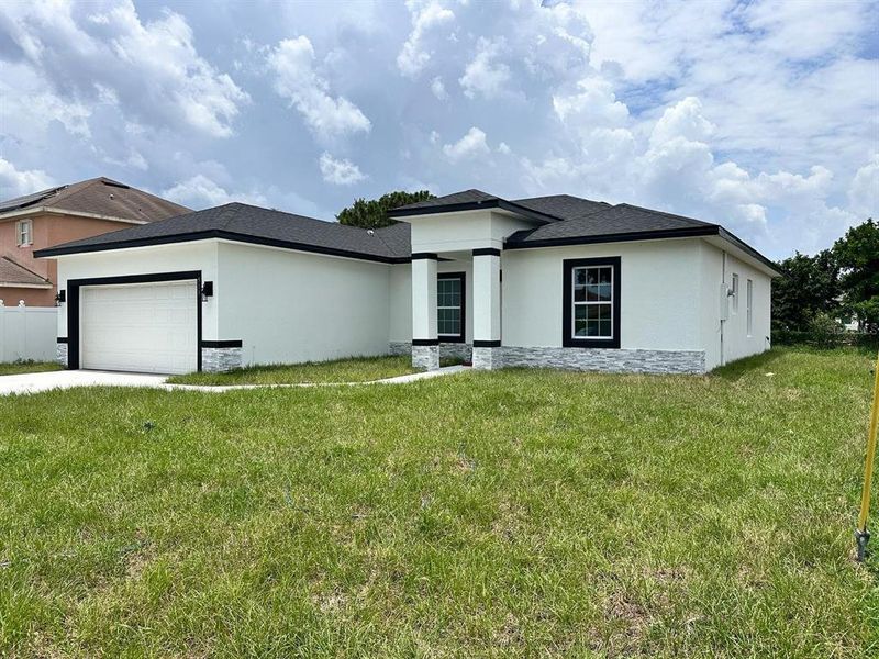 Front exterior of a new home in , Poinciana, FL, highlighting curb appeal (Image 19). Front exterior of a new home in , Poinciana, FL, highlighting curb appeal (Image 19).