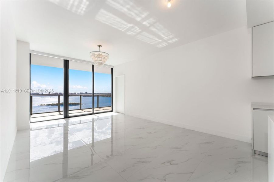 Serene primary suite offering unobstructed water views, direct terrace access, oversized walk-in closets, and floor-to-ceiling windows for a true 'mansion in the sky' feel.