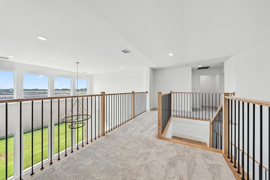 Hallway featuring carpet floors, recessed lighting, a water view, and an upstairs landing