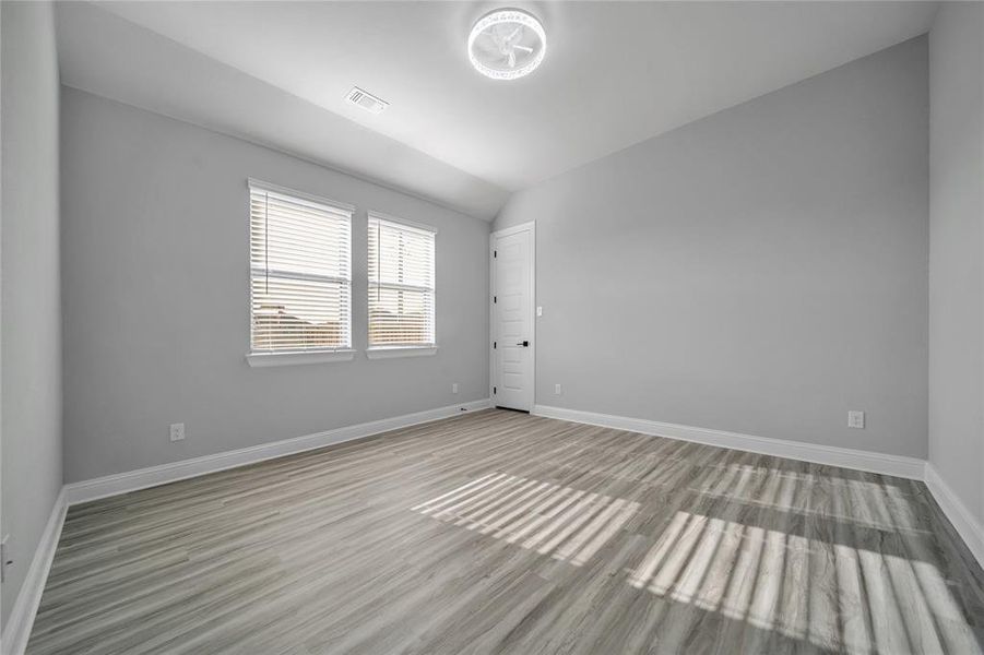 Spare room with vaulted ceiling and light wood finished floors Spare room with vaulted ceiling and light wood finished floors