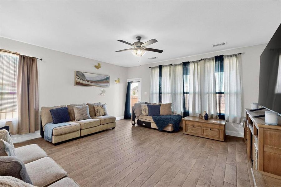 Living area with light wood finished floors and a ceiling fan Living area with light wood finished floors and a ceiling fan