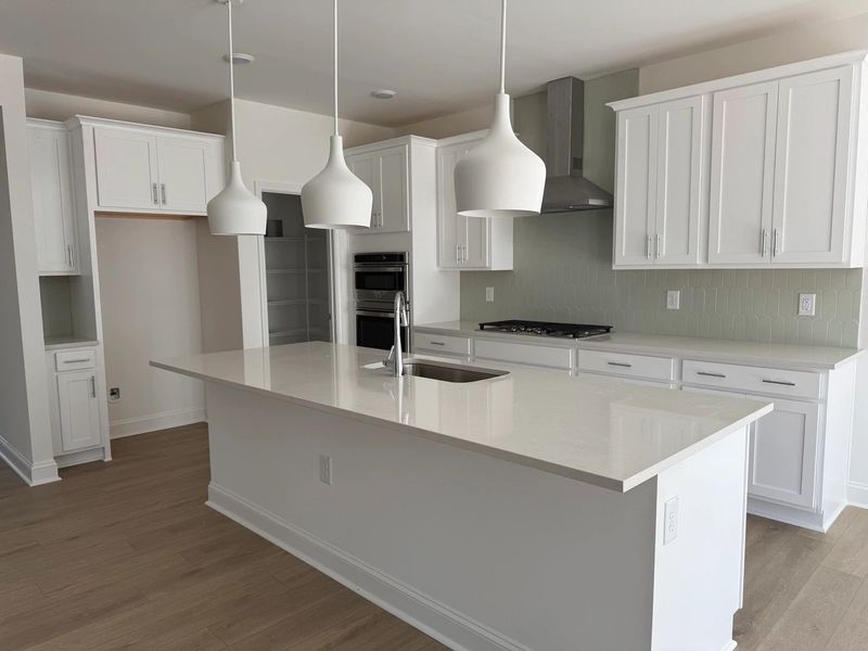 Kitchen featuring the AW Collection® Coastal - White cabinets and sea-glass tile backsplash. Kitchen featuring the AW Collection® Coastal - White cabinets and sea-glass tile backsplash.