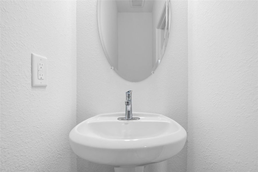 The powder room on the first floor includes a pedestal sink, mirror, and toilet to conveniently meet your needs. The powder room on the first floor includes a pedestal sink, mirror, and toilet to conveniently meet your needs.