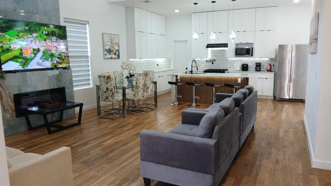 Spacious open-concept living area featuring wood-finish flooring