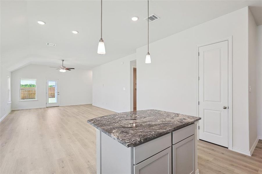 Kitchen featuring a center island, light hardwood / wood-style flooring, decorative light fixtures, gray cabinets, and ceiling fan