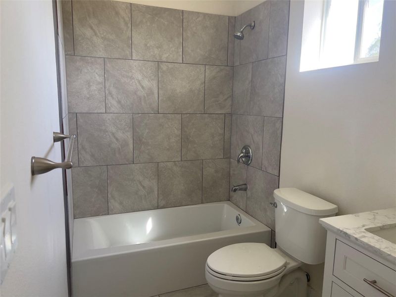A well-appointed bathroom with a sleek vanity and tiled shower offers practical comfort.