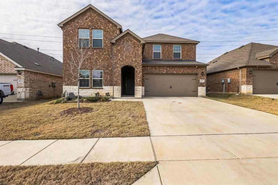 View of property with a front yard and a garage