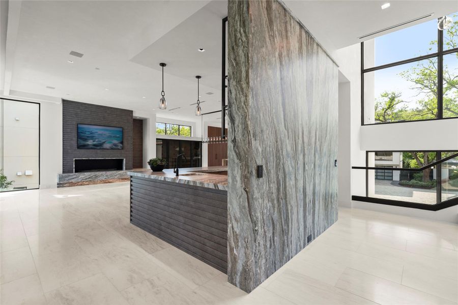 Bookmatcched marble entry in front of glass evevator.