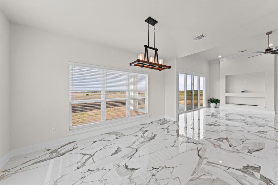 Polished stone-look tile floors and large windows define this bright, open living space.
