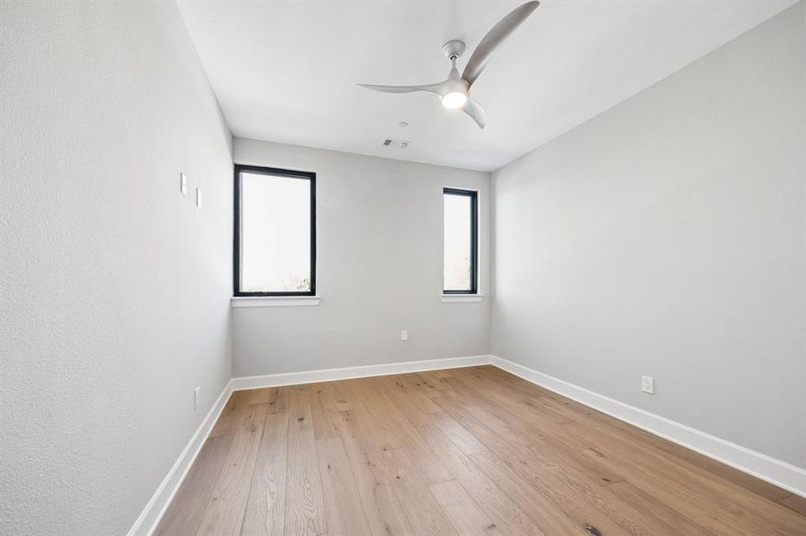 Empty room featuring ceiling fan and light wood-type flooring Empty room featuring ceiling fan and light wood-type flooring