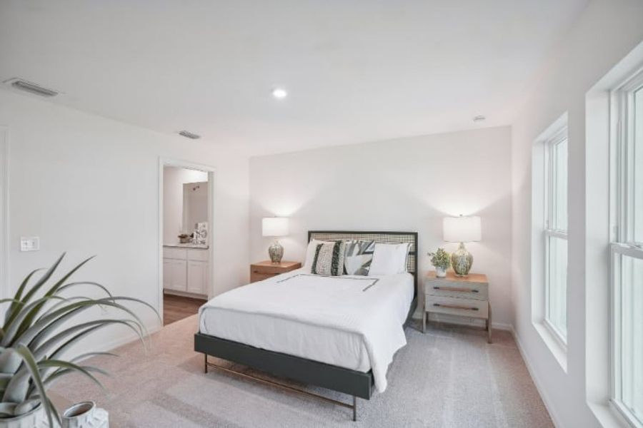 A bedroom with a bed and lamps.