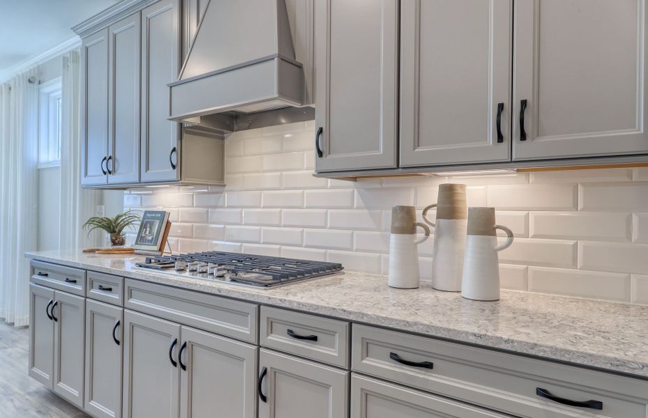 The kitchen's chic ambiance is elevated by its sleek gray cabinets paired harmoniously with a beautifully crafted wood.