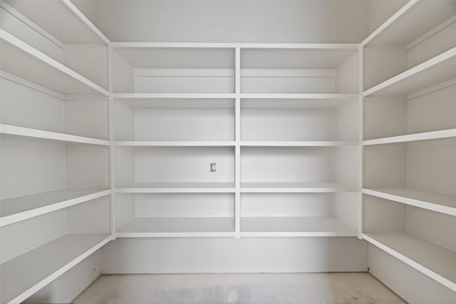 Expansive walk in pantry with custom cabinetry