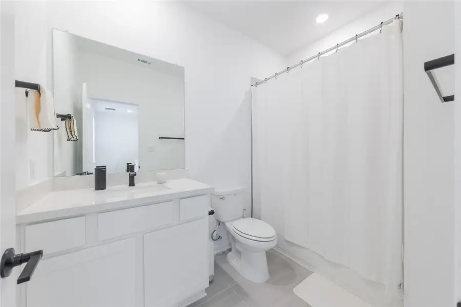 Full bathroom featuring vanity, shower / bath combination with curtain, light tile patterned floors, and recessed lighting