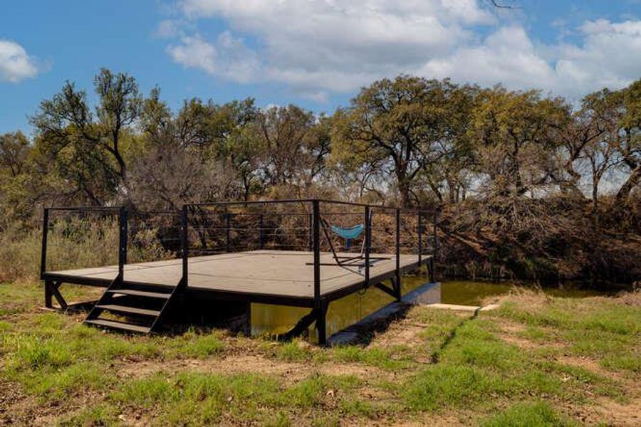 View of home's community with view of wooded area and a deck