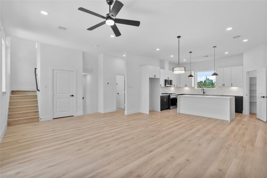 Sunlit open living space anchored by a chef-inspired kitchen with oversized island and designer lighting Sunlit open living space anchored by a chef-inspired kitchen with oversized island and designer lighting