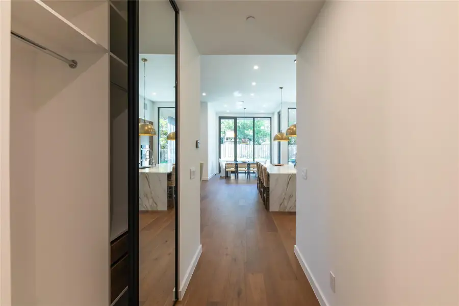 A streamlined corridor with built-in storage leads to an open-concept living space.
