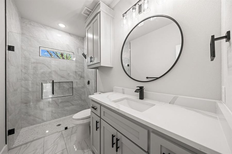 Bathroom with vanity, a stall shower, light marble finish flooring, and recessed lighting