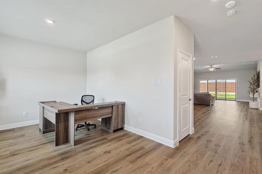 Home office with ceiling fan and wood-type flooring