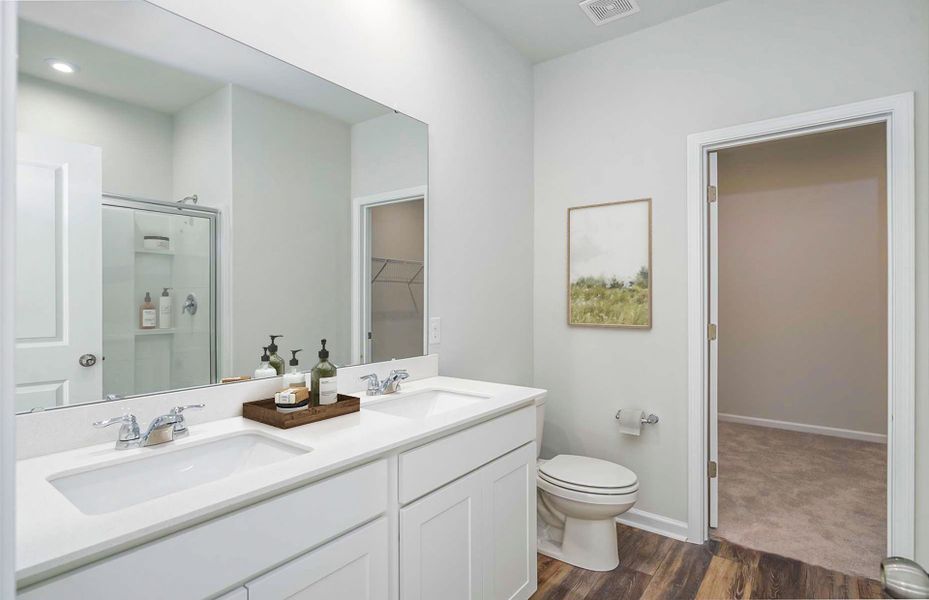 Owner's suite bath with dual vanities and a spacio