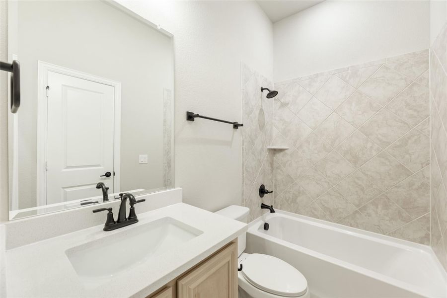 Bathroom with white vanity, tub-shower combo with diagonal tile surround, and dark bronze fixtures Bathroom with white vanity, tub-shower combo with diagonal tile surround, and dark bronze fixtures