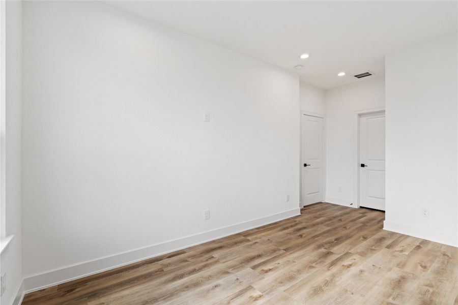 Another view of the bedroom showing ample wall space and a flexible layout.