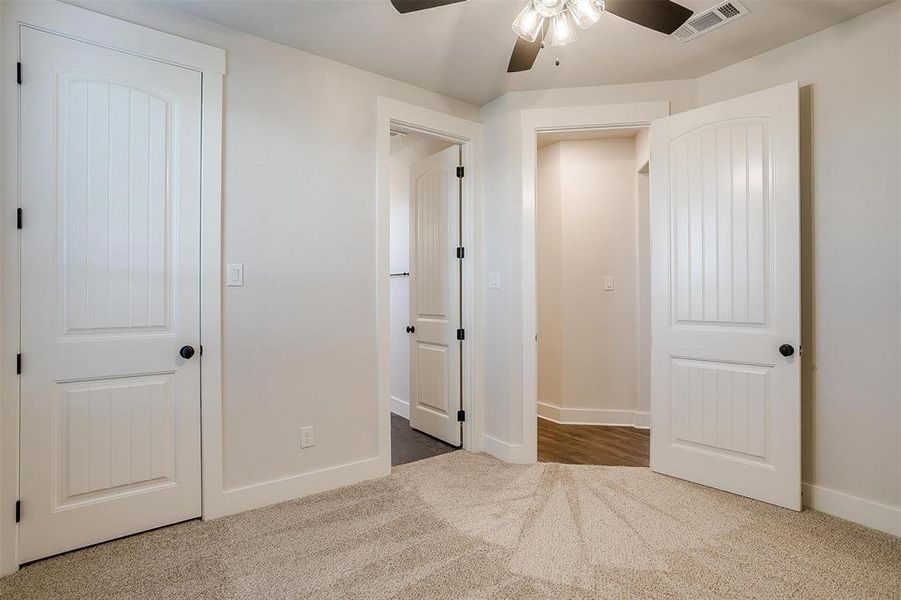 Unfurnished bedroom featuring ceiling fan and carpet