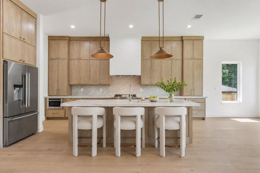 Oversized island, designer lighting and abundant natural light. Virtual staging.