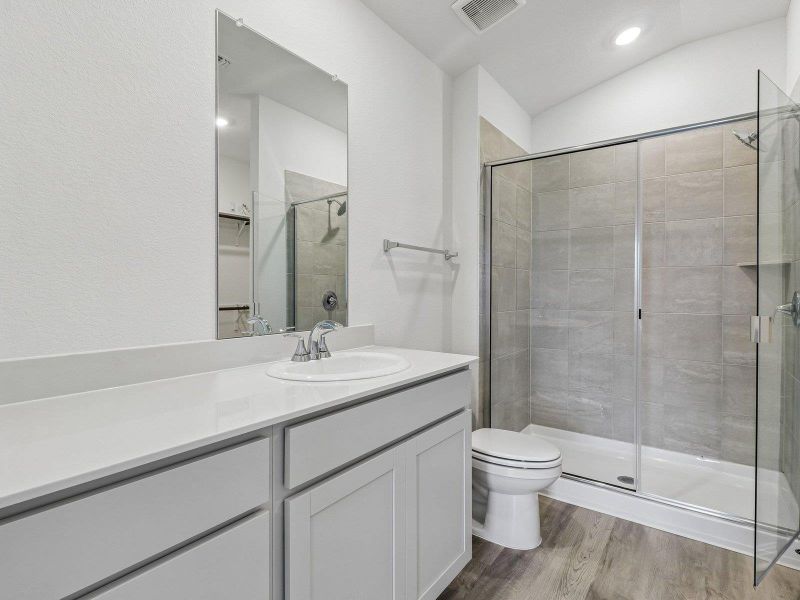 Modern cabinetry and a glass-enclosed shower define this streamlined bathroom space.