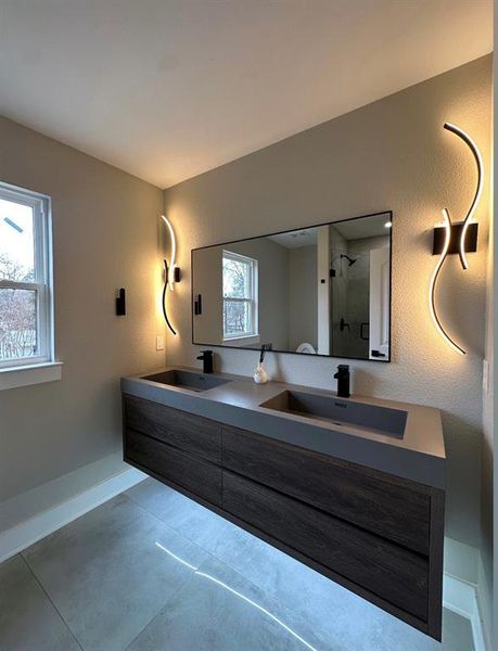 Bathroom featuring vanity, a wealth of natural light, and a shower with door