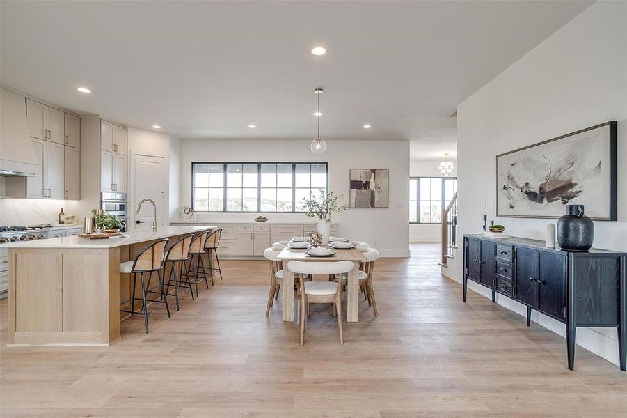 Dining room with recessed lighting, light wood-type flooring, and stairs