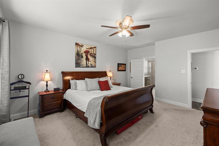 Bedroom with carpet, ceiling fan, and connected bathroom Bedroom with carpet, ceiling fan, and connected bathroom