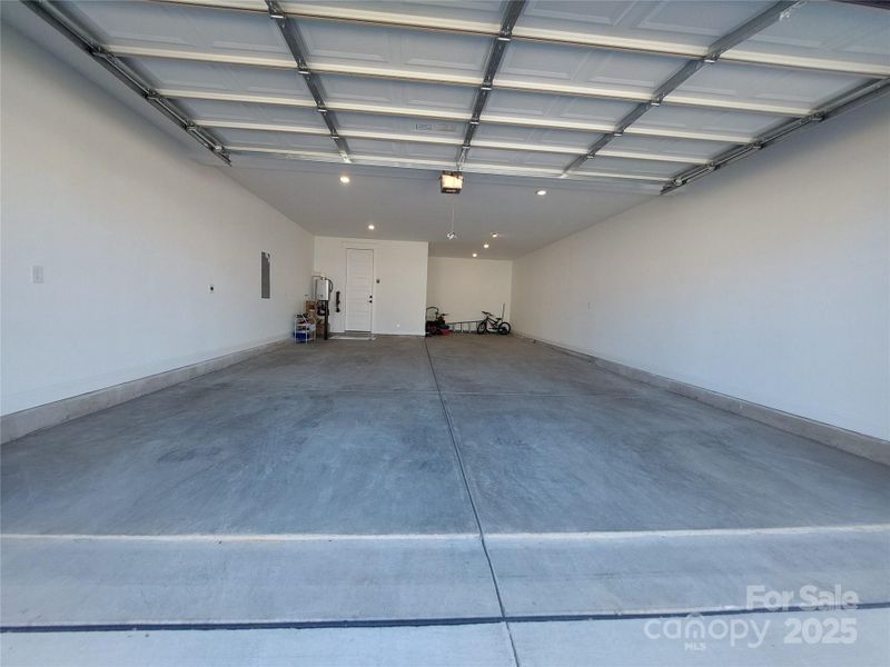 A generously sized two-car garage with an extended bay that provides a flexibility to park a 3rd car in tandem or use the space for a storage or a workshop