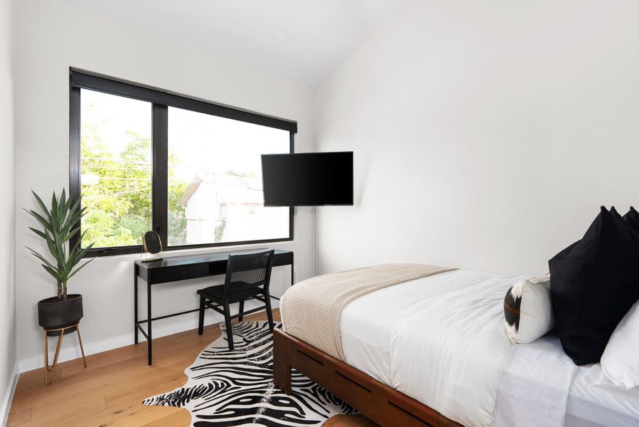 Bedroom with light wood-style floors and vaulted ceiling Bedroom with light wood-style floors and vaulted ceiling