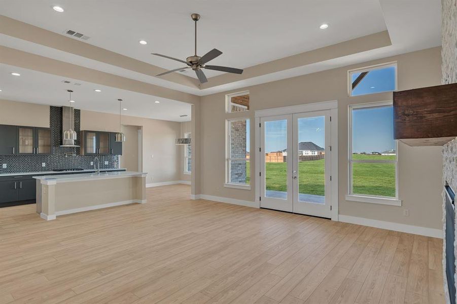 Kitchen with light countertops, a tray ceiling, visible vents, and range hood