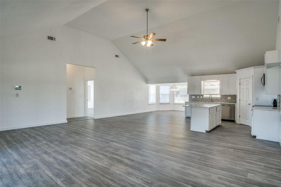 Kitchen with a center island, wood-type flooring, dishwasher, and white cabinets Kitchen with a center island, wood-type flooring, dishwasher, and white cabinets