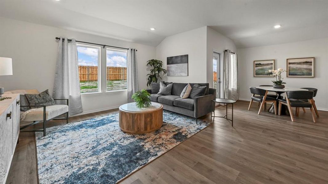 Living area featuring vaulted ceiling, wood finished floors, and recessed lighting Living area featuring vaulted ceiling, wood finished floors, and recessed lighting