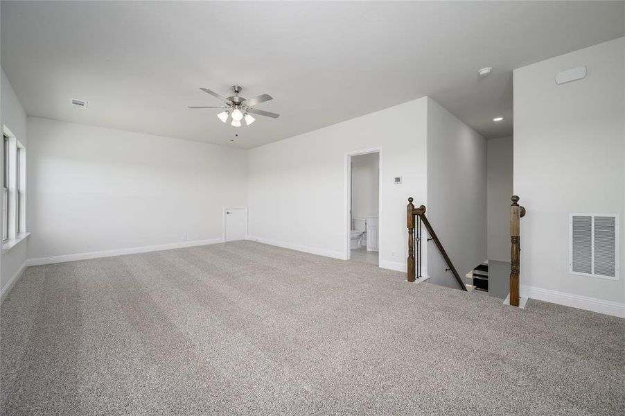 Carpeted spare room featuring ceiling fan