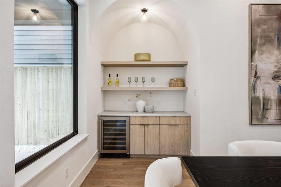 Entaining bar - features custom built-ins, a beverage cooler, and a curved accent wall with designer lighting. Entaining bar - features custom built-ins, a beverage cooler, and a curved accent wall with designer lighting.