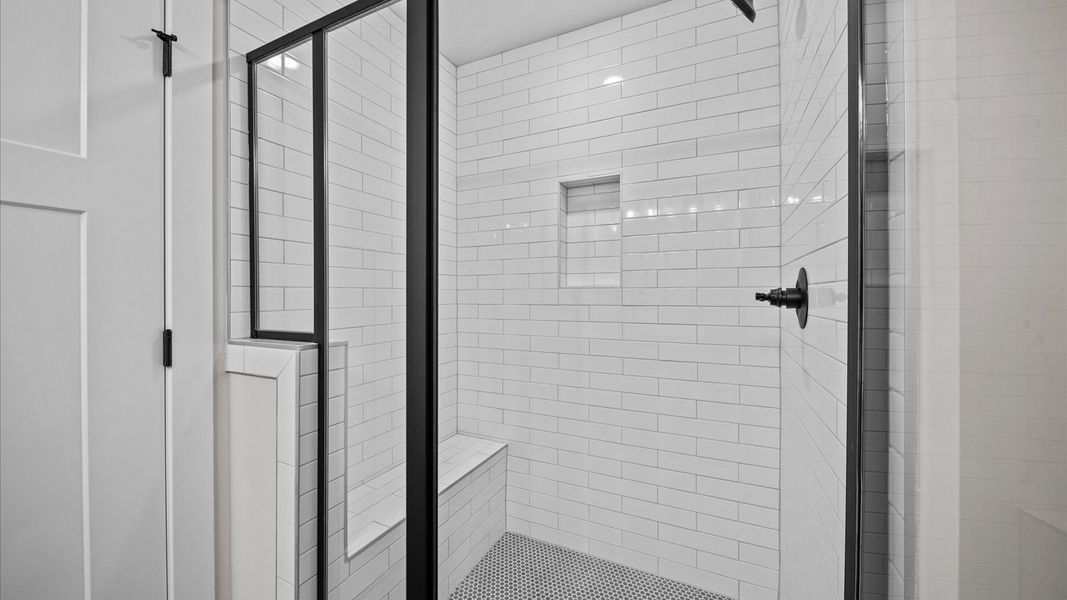 White brick tiled walk-in shower with bench seat in two story townhome at Ransdell Pointe by DRB Homes in Spartanburg, SC White brick tiled walk-in shower with bench seat in two story townhome at Ransdell Pointe by DRB Homes in Spartanburg, SC