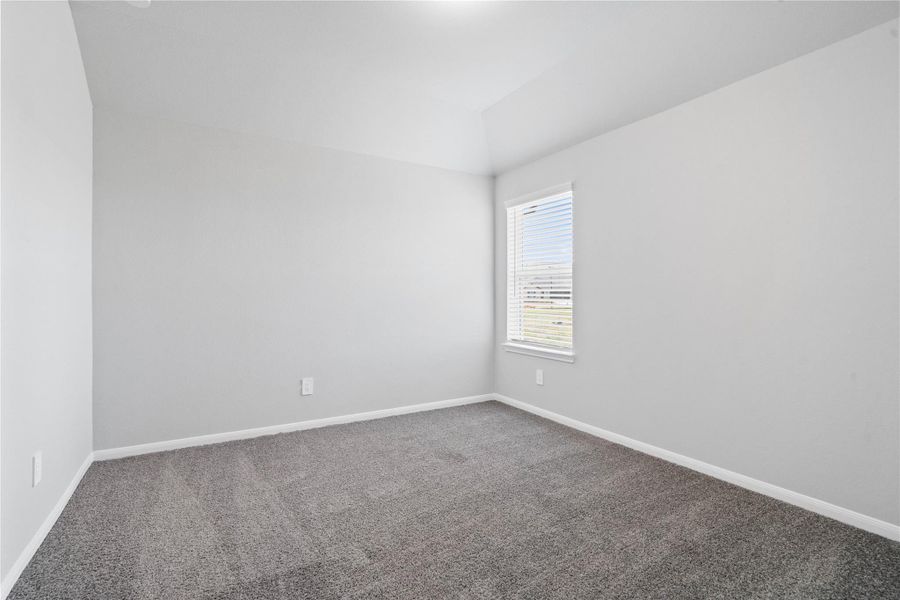 Perfect for guests or a quiet home office, this room features soft plush carpeting, a window with fitted blinds, sloped ceiling, and ample sized closet space.