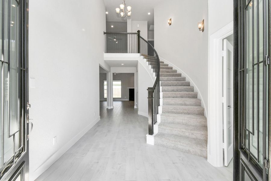 As you step into the threshold of this luxurious home, you'll soon be welcomed by an elegant glass door. Inside, soaring ceilings amplify the spaciousness, while the refined wood-look tile flooring and oversized baseboards exude sophistication and charm. Sample photo of completed home with similar floor plan. Actual colors and selections may vary. As you step into the threshold of this luxurious home, you'll soon be welcomed by an elegant glass door. Inside, soaring ceilings amplify the spaciousness, while the refined wood-look tile flooring and oversized baseboards exude sophistication and charm. Sample photo of completed home with similar floor plan. Actual colors and selections may vary.