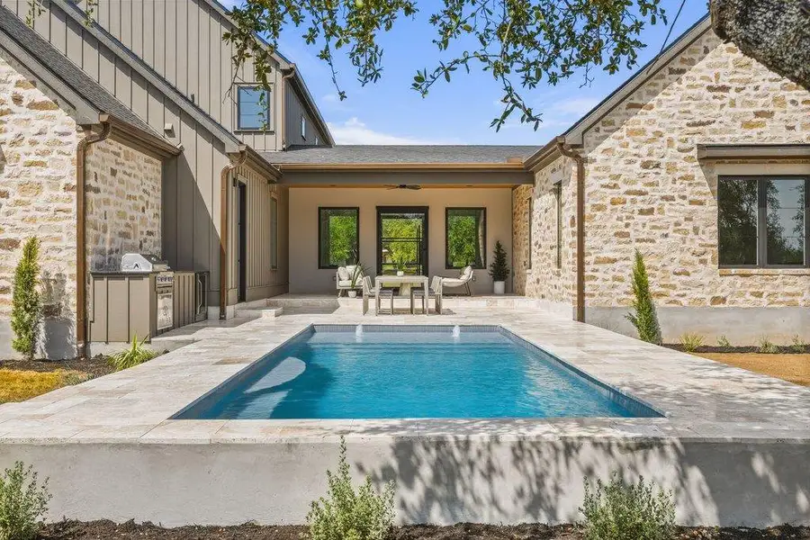 A private courtyard oasis with a sleek swimming pool, inviting covered patio, and built-in barbecue for al fresco entertaining.