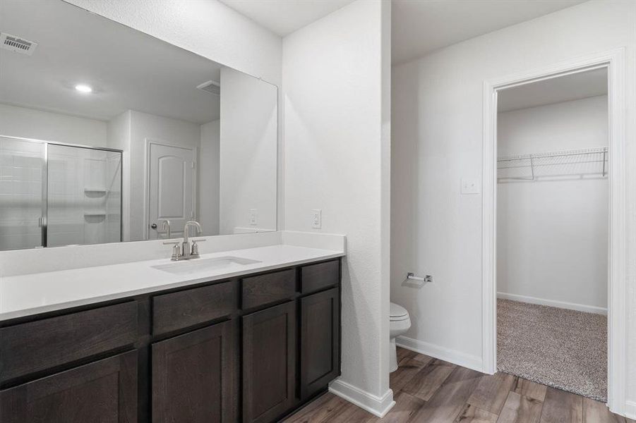 Bathroom featuring vanity, toilet, and wood-type flooring