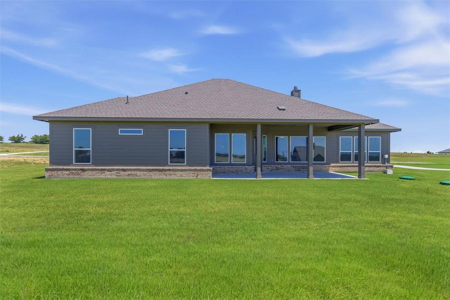 Expansive green lawn bordering the rear exterior of the property