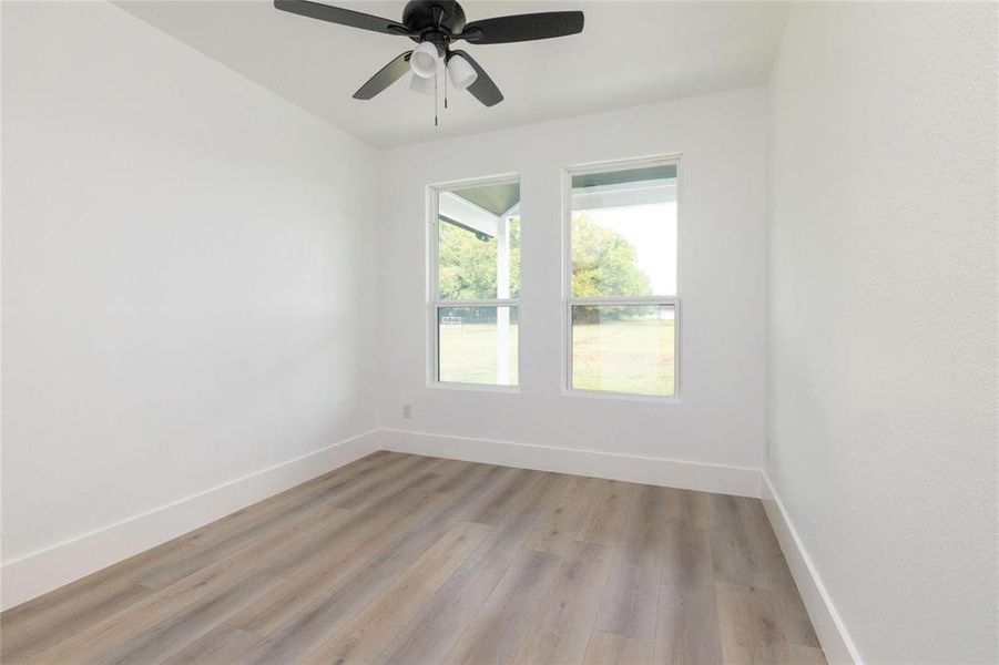 Empty room featuring ceiling fan and light hardwood / wood-style flooring