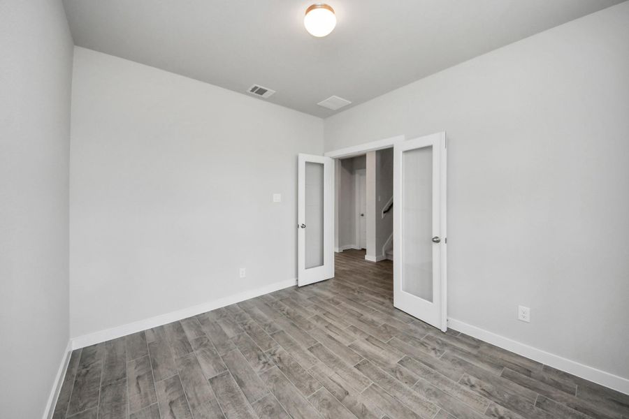 Experience the perfect blend of sophistication and warmth in this home office, boasting elegant wood-look tile flooring and flooded with natural light from expansive windows and French doors. Experience the perfect blend of sophistication and warmth in this home office, boasting elegant wood-look tile flooring and flooded with natural light from expansive windows and French doors.