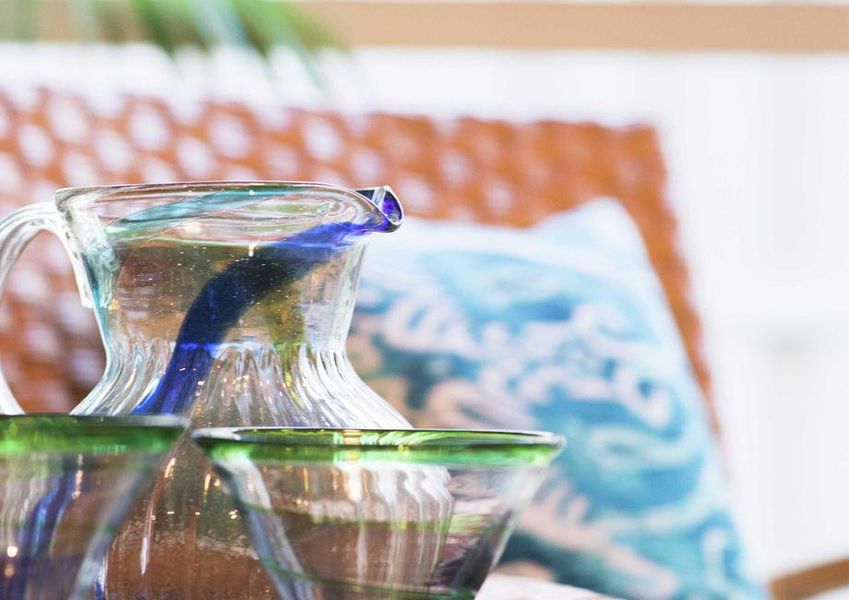 This home is decorated with blue throw pillows, mid-century modern sofa, and glass centerpiece.