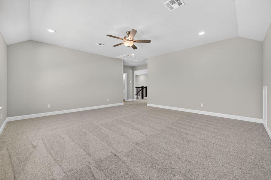 Spare room featuring lofted ceiling, light colored carpet, attic access, ceiling fan, and recessed lighting